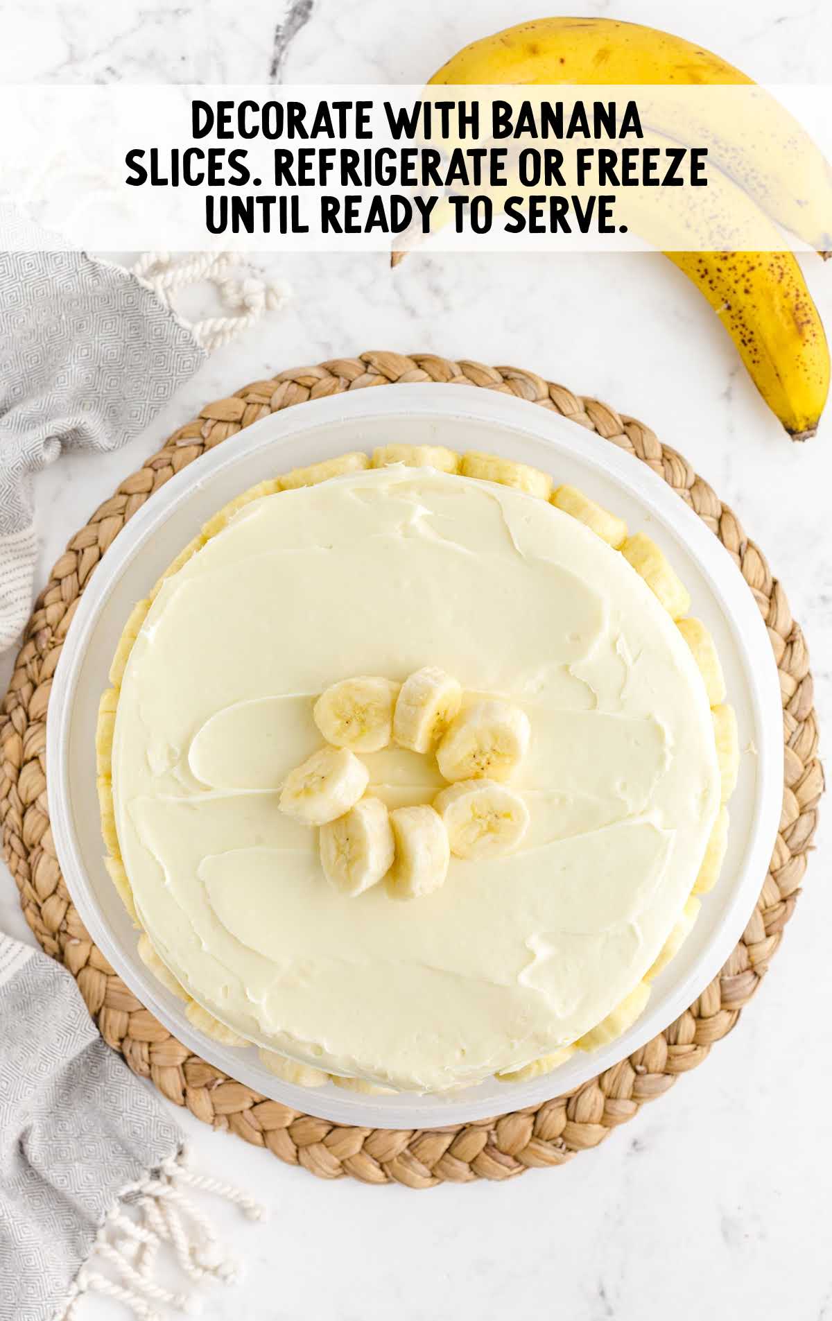banana slices placed on top of the cake on a cake stand