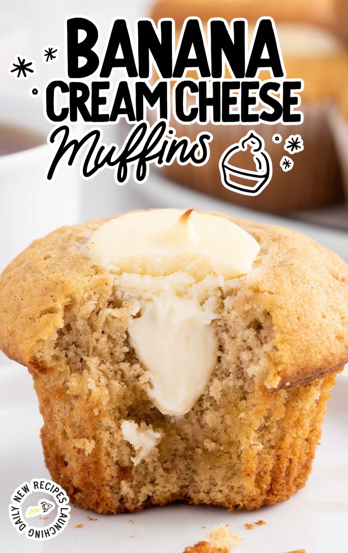 a close up shot of a Banana Cream Cheese Muffin with a bite taken out of it