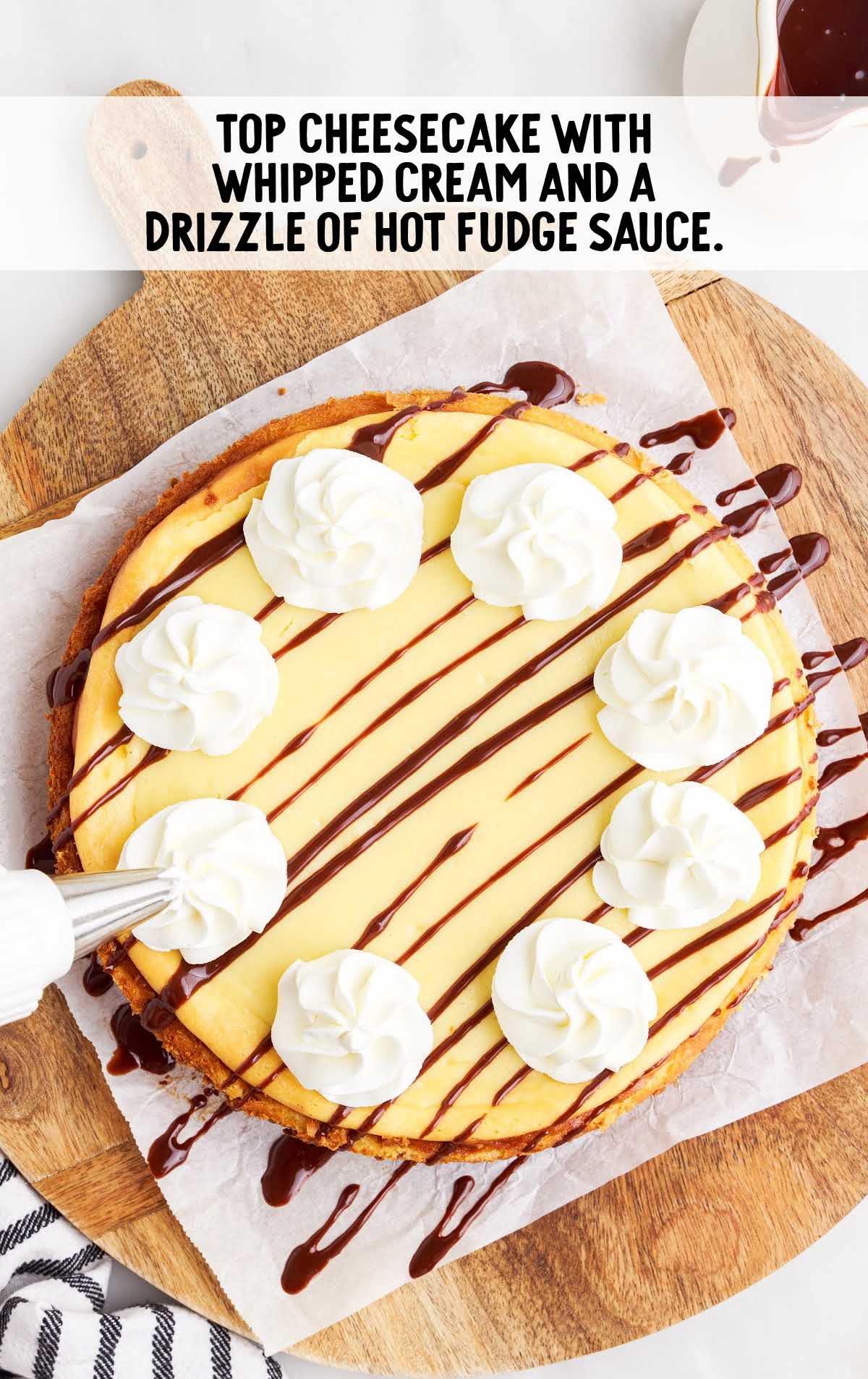 cheescake topped with whipped cream and drizzled with hot fudge sauce