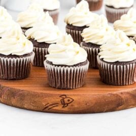 a bunch of cupcakes topped with Cool Whip Frosting on a wooden tray