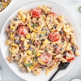 overhead shot of Cowboy Pasta Salad with dressing in a bowl