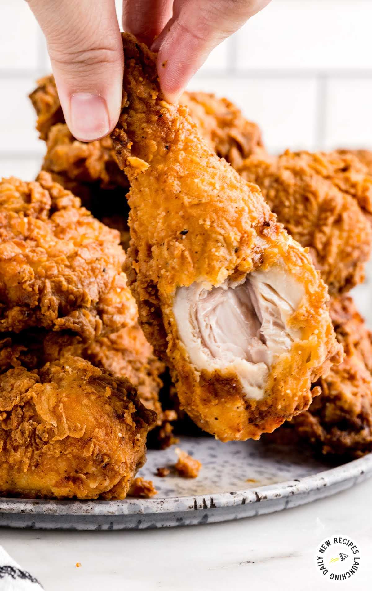 close up shot of a piece of Fried Chicken with a bite taken out of it