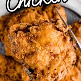close up shot of a piece of Fried Chicken with tongs