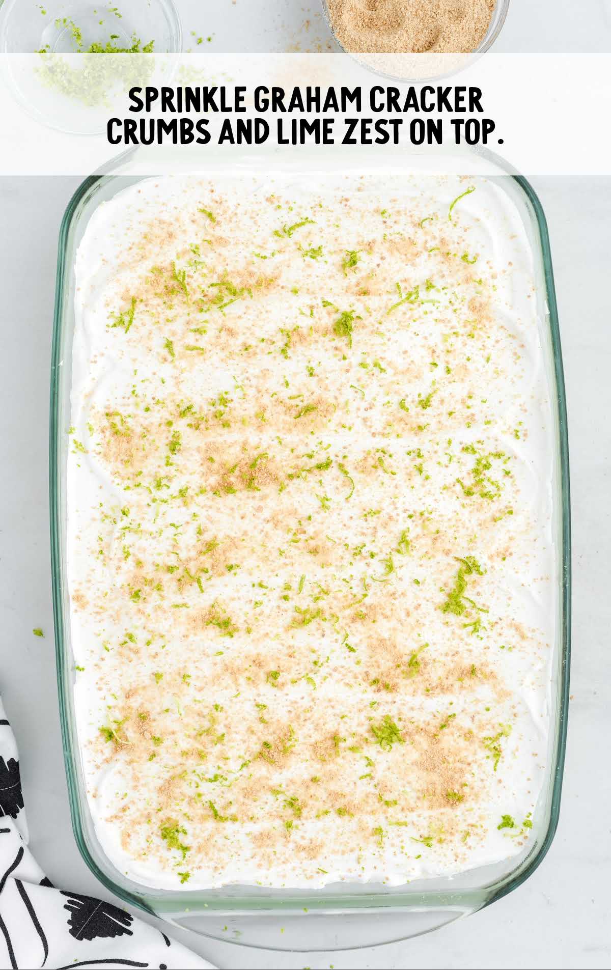 graham crackers and lime zest sprinkled on top of the pie in a baking dish