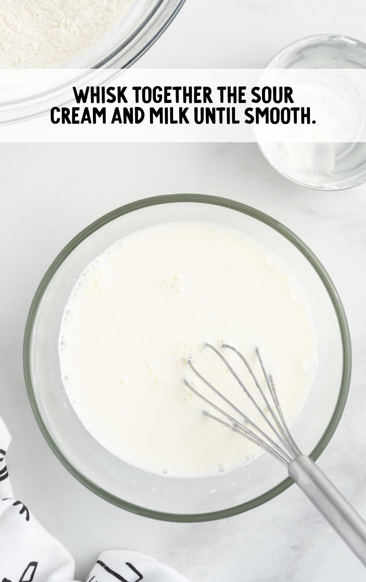 sour cream and milk whisked together in a bowl