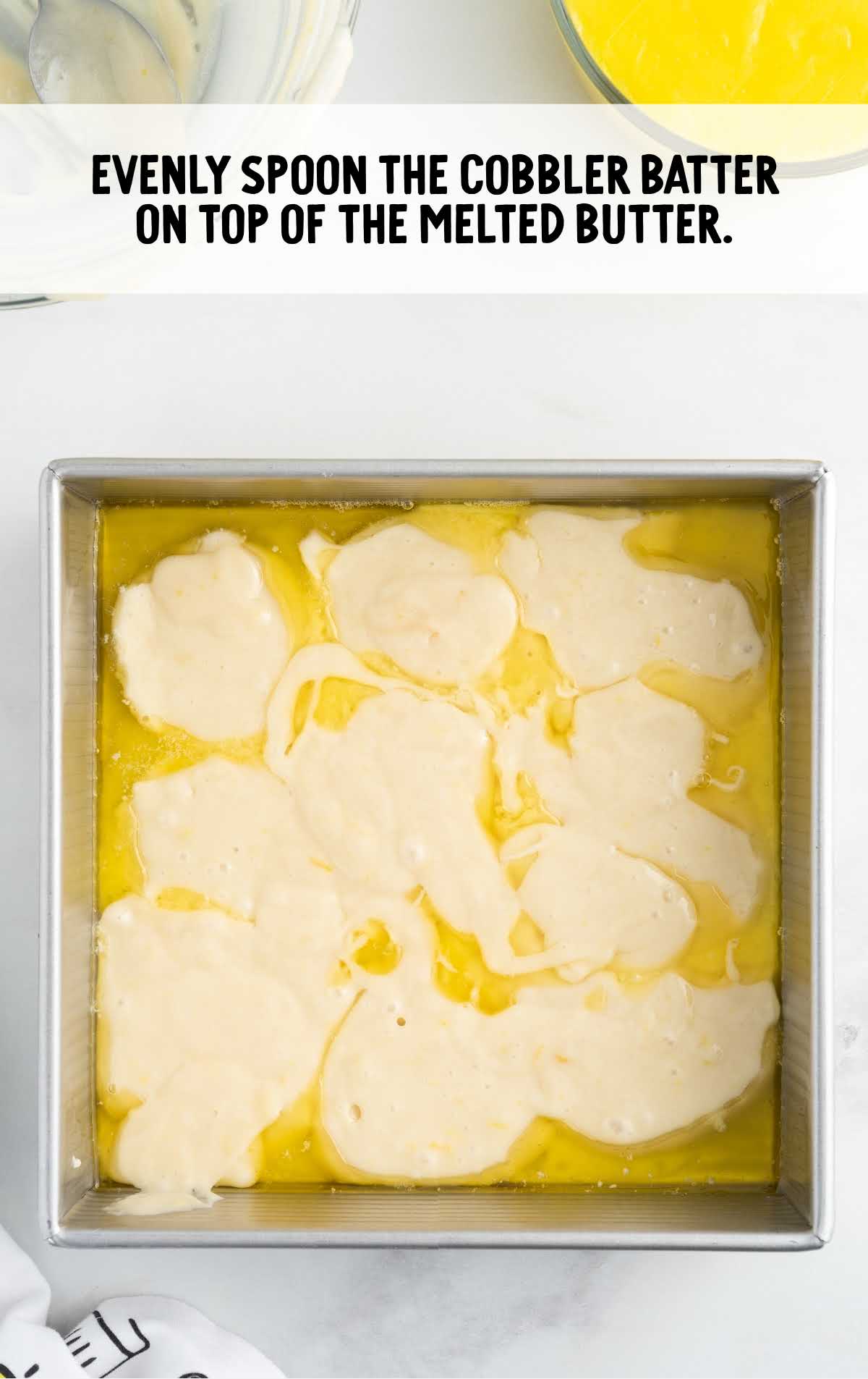 cobbler batter poured on top of the melted butter in a baking dish