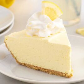 close up shot of a slice of Lemonade Pie on a plate topped with whipped cream