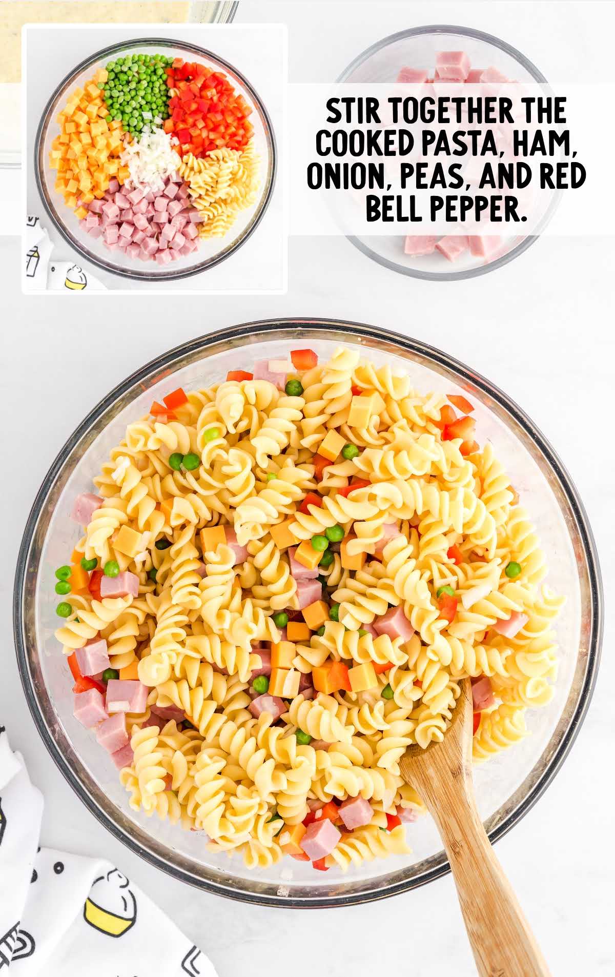pasta, ham, onion, peas, and red bell pepper stir together in a bowl
