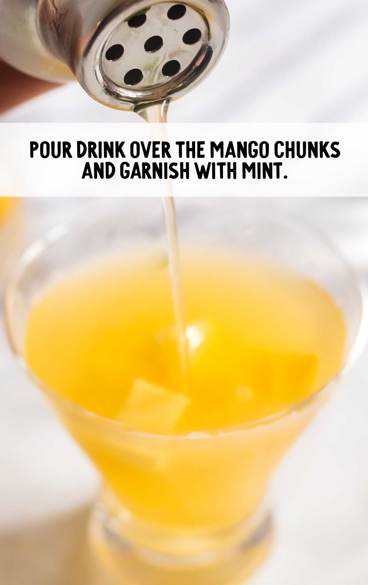 drink poured over mango chunks in a glass