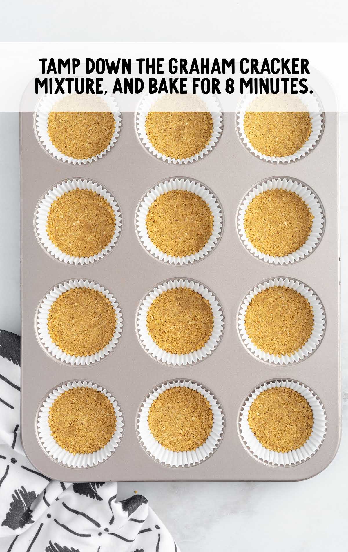 baked graham cracker mixture in a cupcake liner and in a cupcake pan