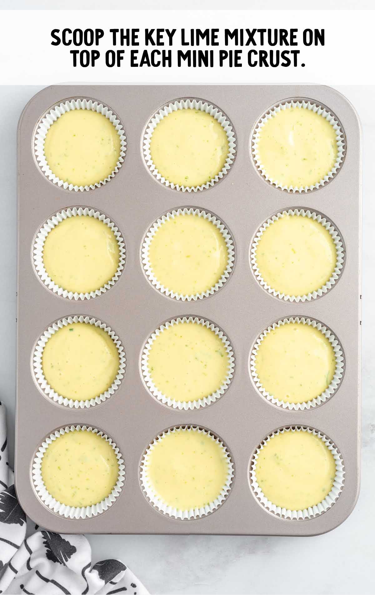 key lime mixture poured in the pie crust in a cupcake pan