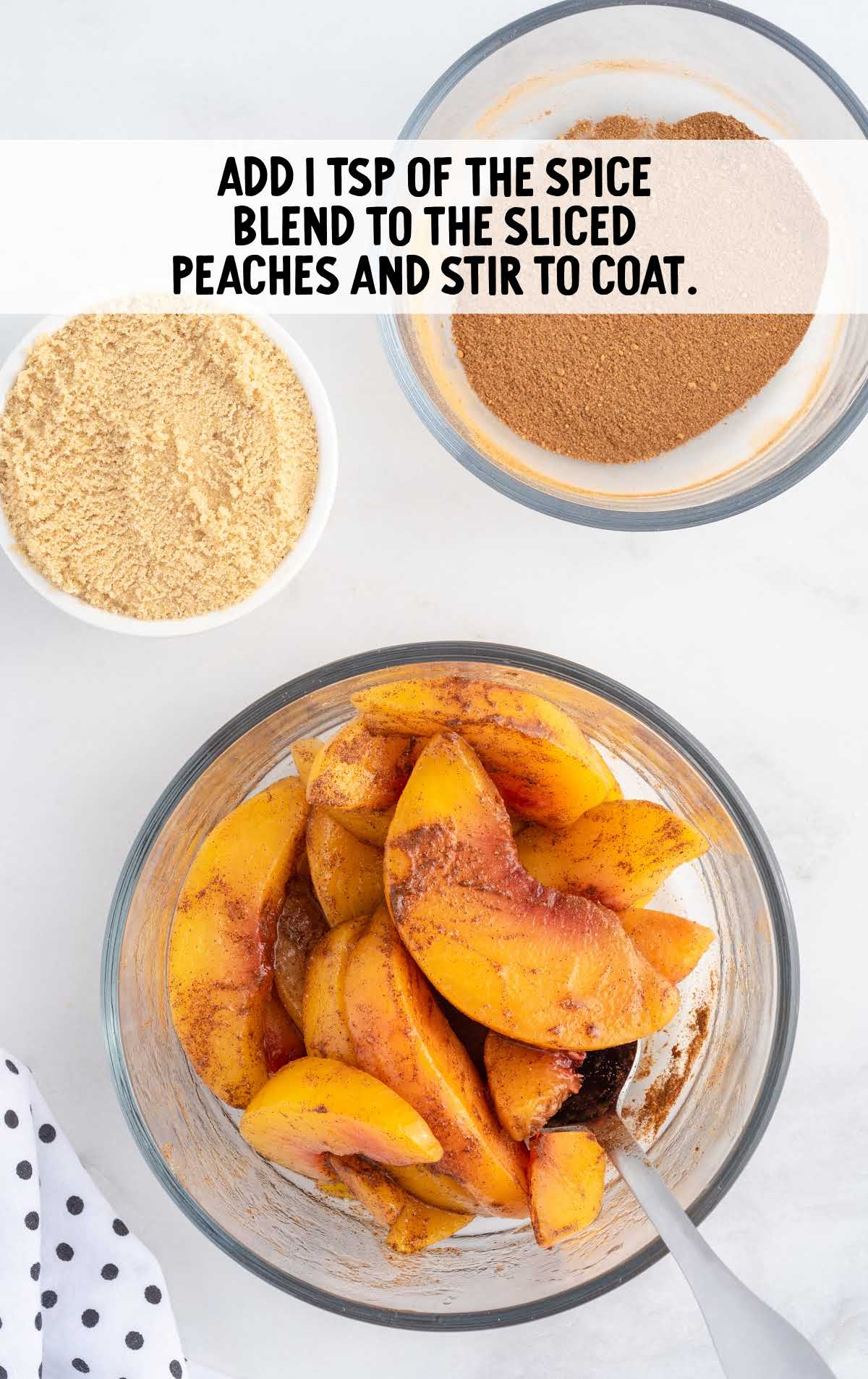 spice blend added to the peaches in a bowl