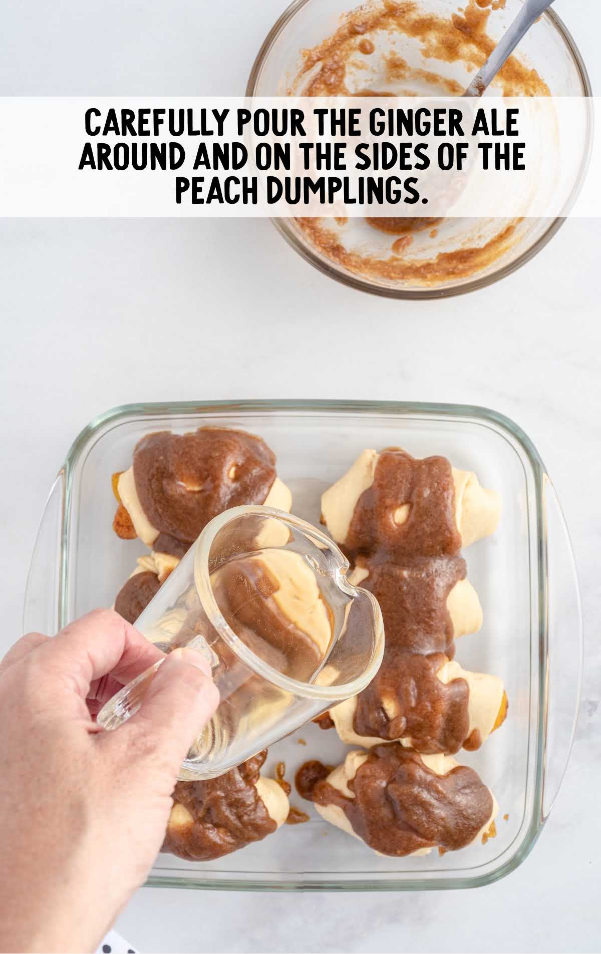 ginger ale poured around and on the sides of the peach dumplings in a baking dish