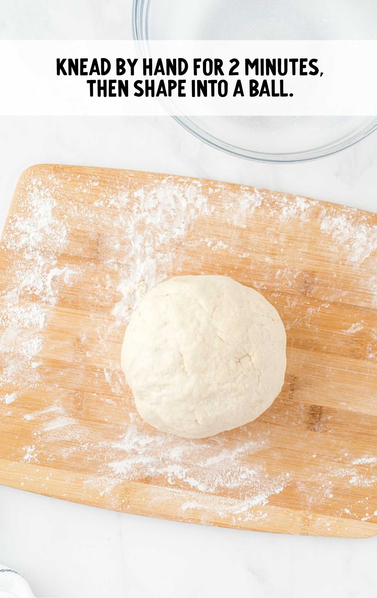 dough formed in a ball on a floured cutting board 