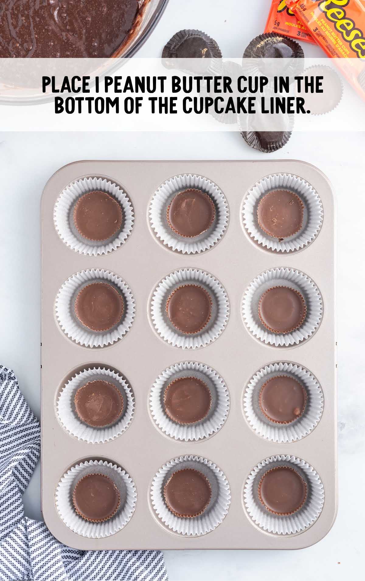 peanut butter cup placed in the bottom of the cupcake liner in a cupcake pan