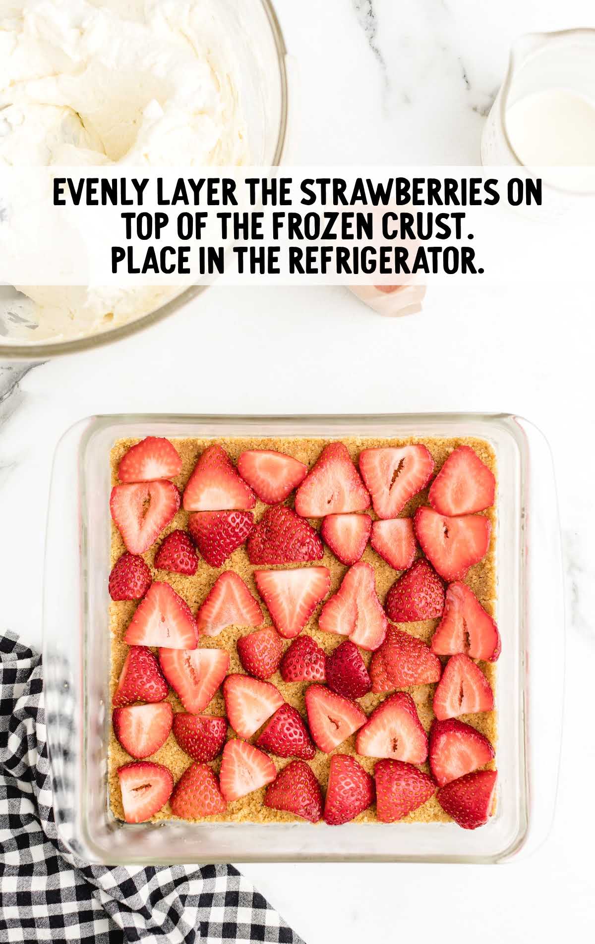 strawberries placed on top of the frozen crust in a baking dish