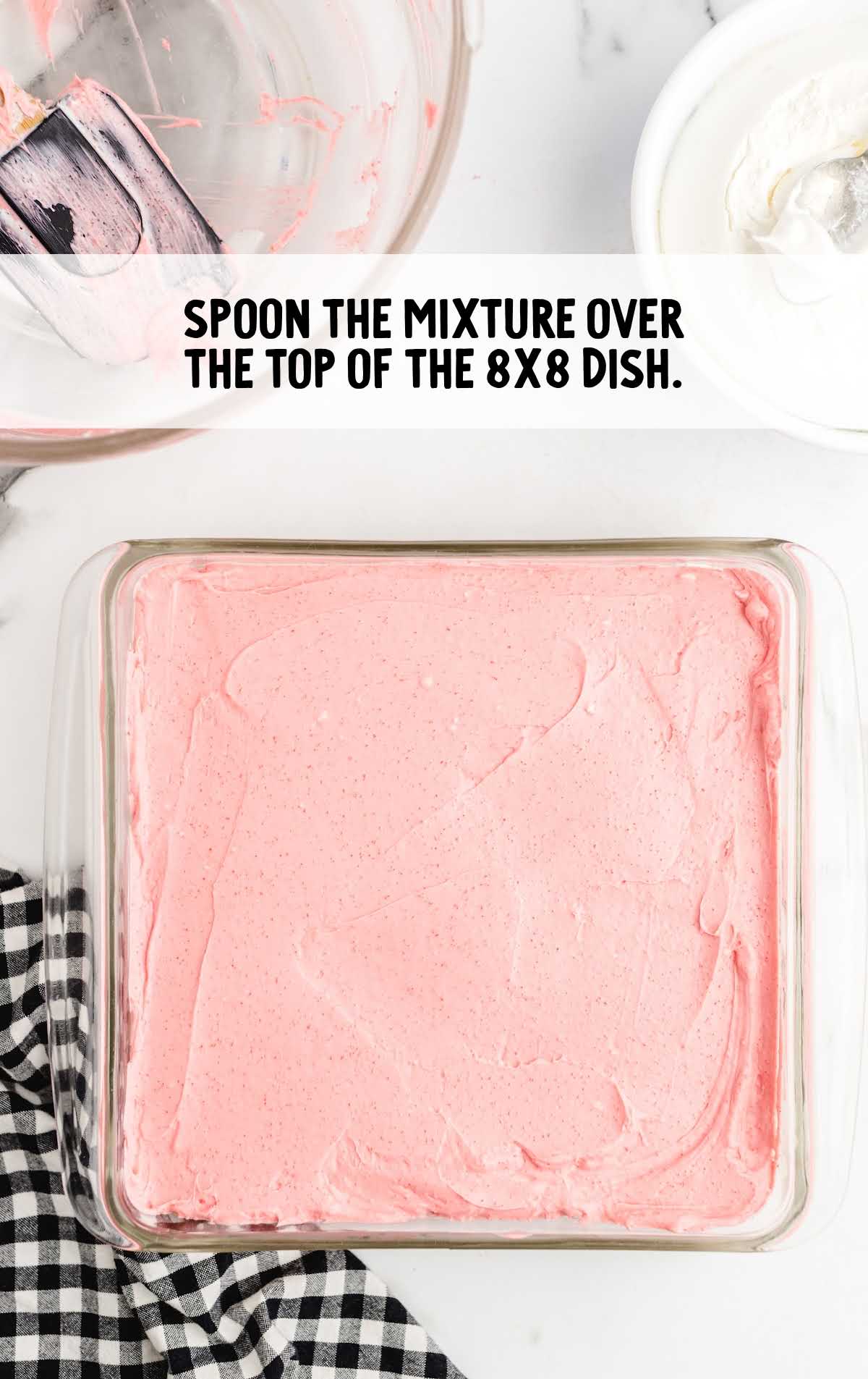 cream cheese and strawberry gelatin mixture spooned over the cake top in a baking dish