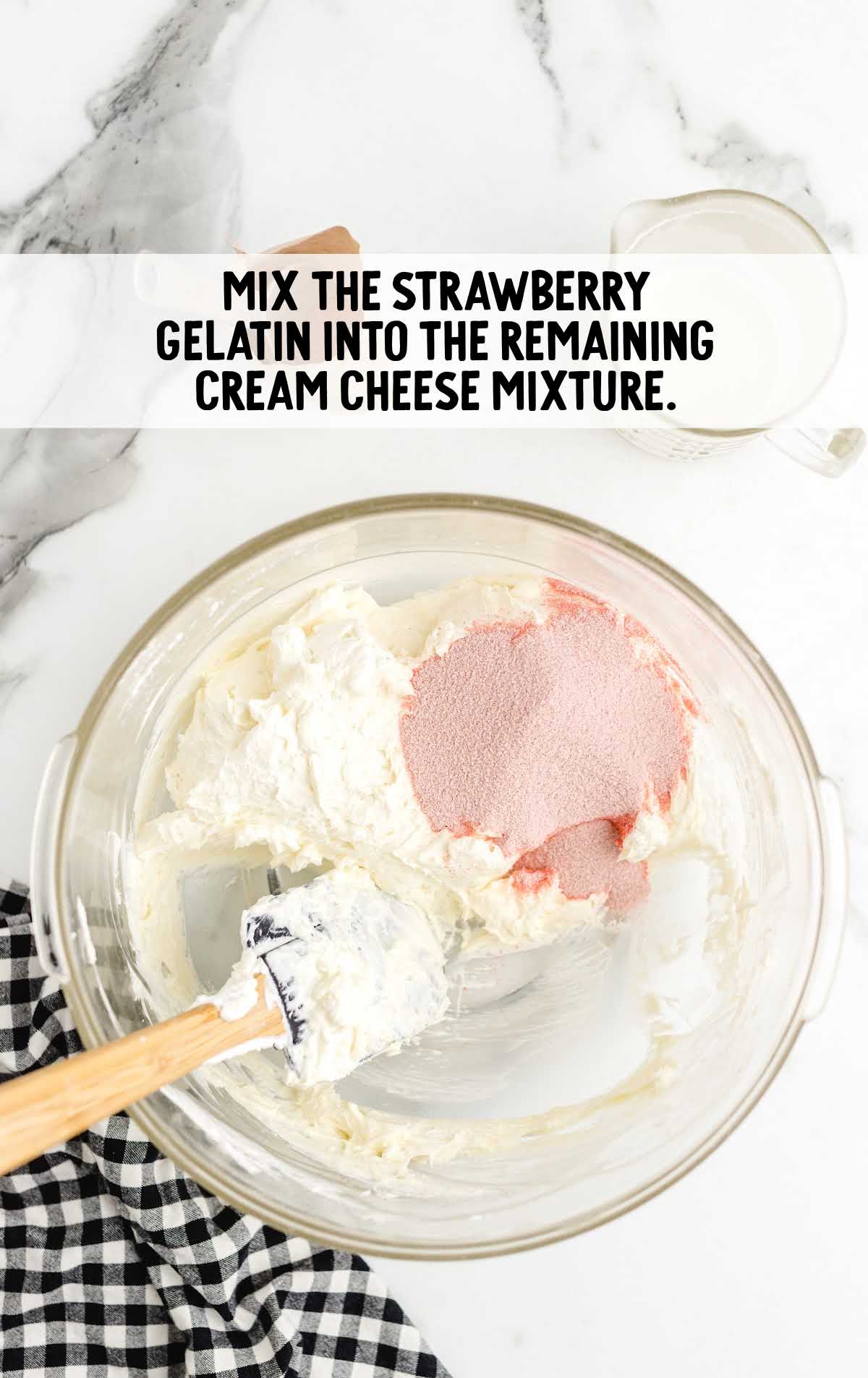 strawberry gelatin and cream cheese mixture folded together in a bowl
