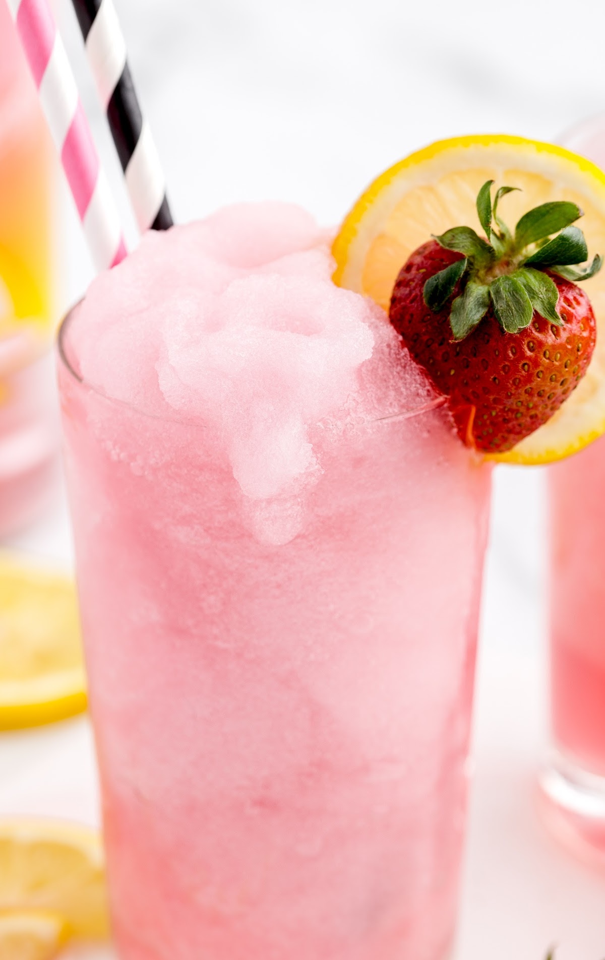 Strawberry Lemonade Cocktail in a glass with a slice of lemon and strawberry in a glass