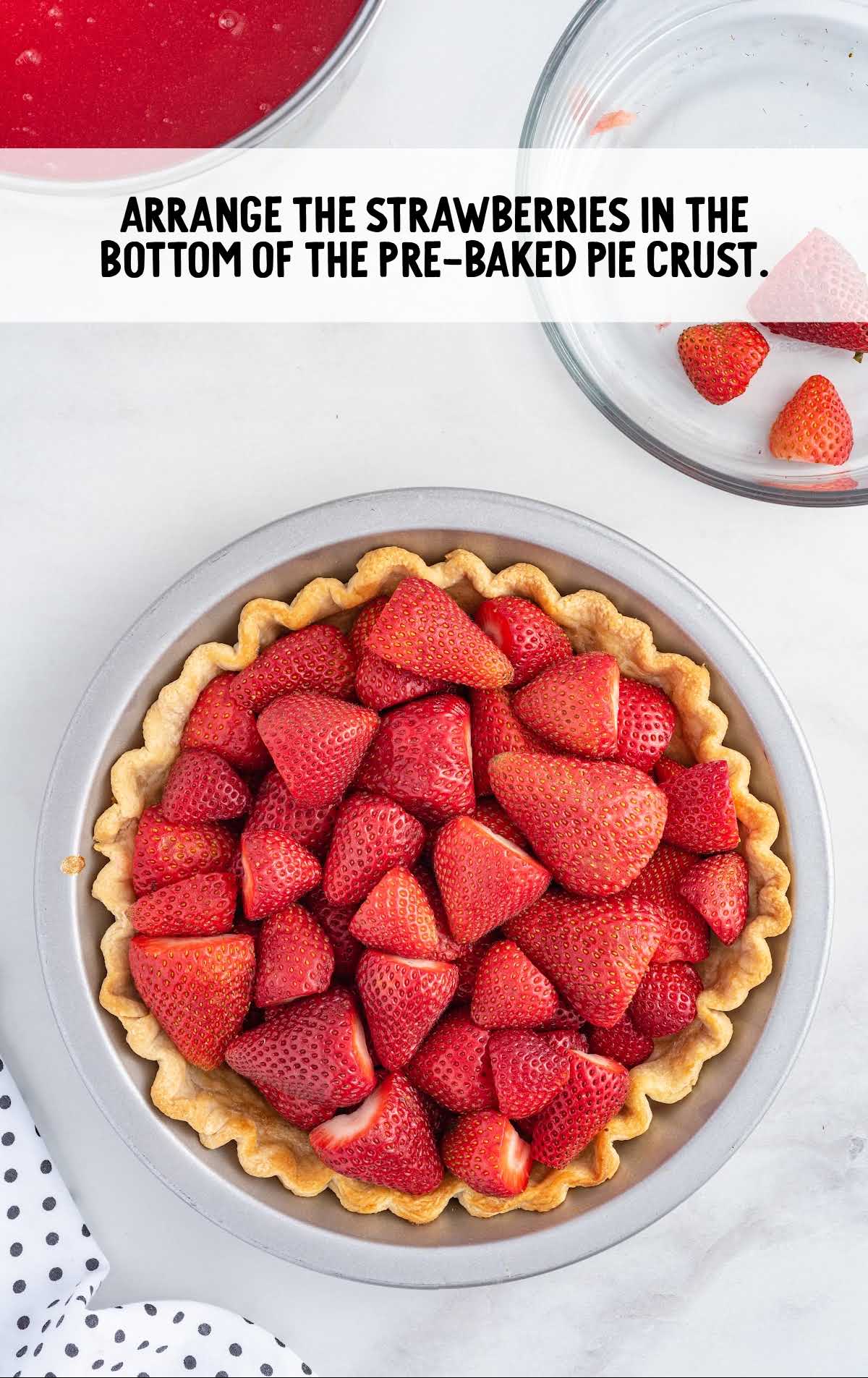 sliced strawberries arranged in the pie in a pie dish