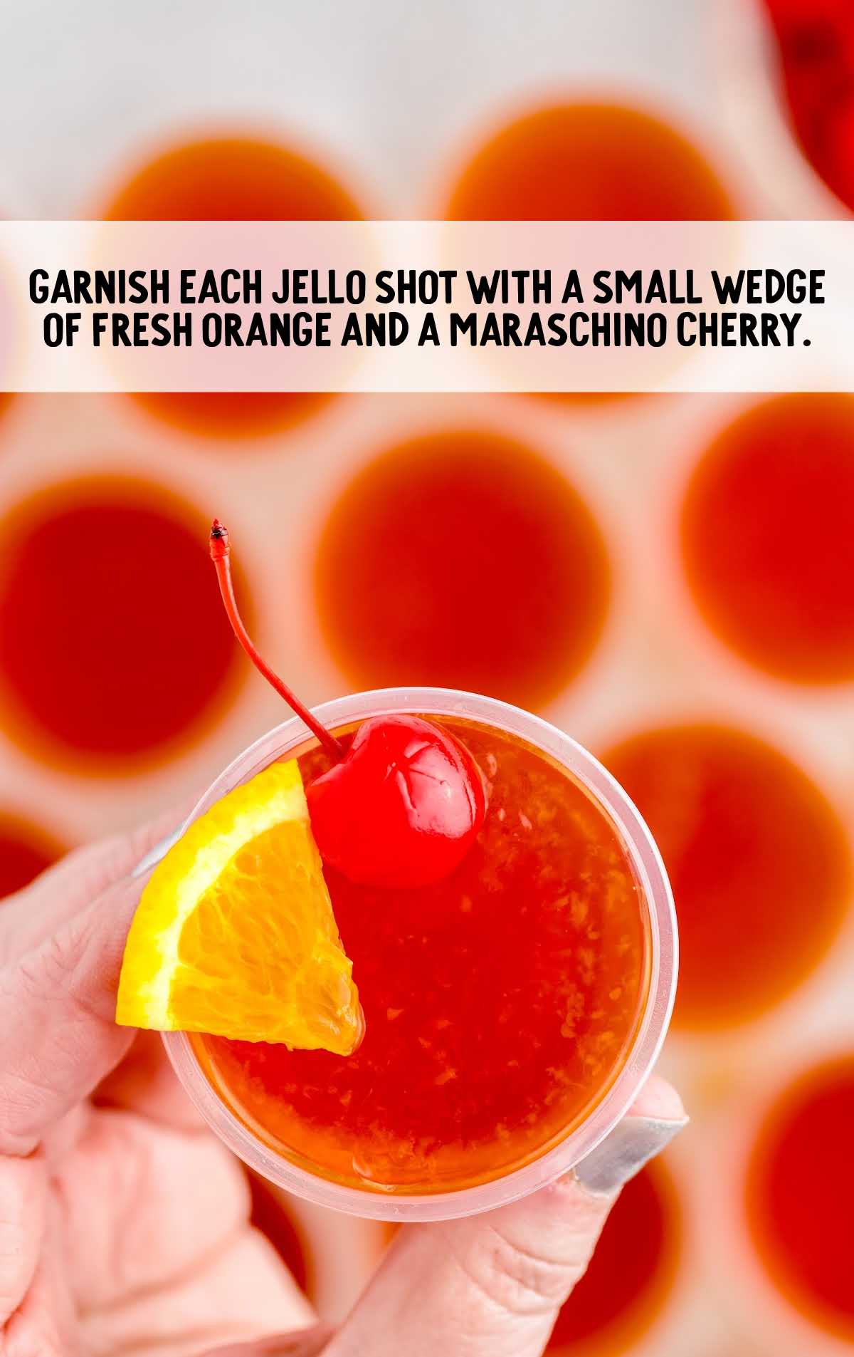 Tequila Sunrise Jello Shots topped with cherry and a slice of orange