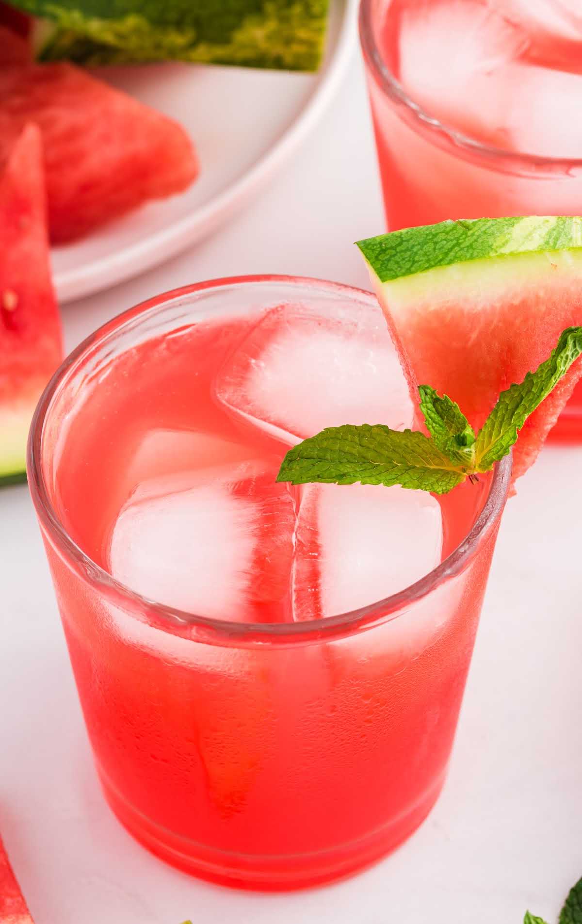 overhead shot of Watermelon Cocktail topped with a watermelon slice and mint in a glass