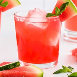 close up shot of Watermelon Cocktail topped with a watermelon slice and mint in a glass