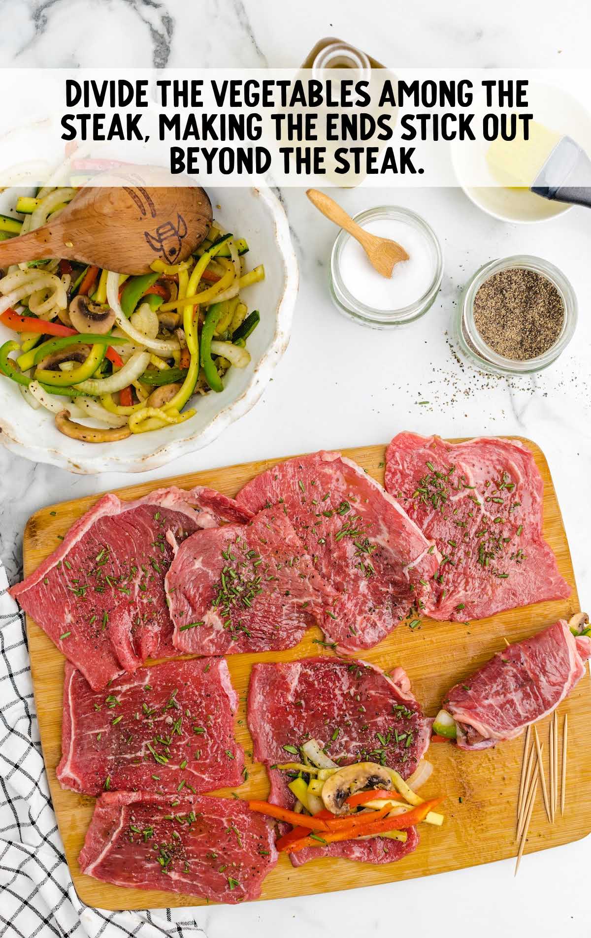 vegetables divided among the steak on a cutting board