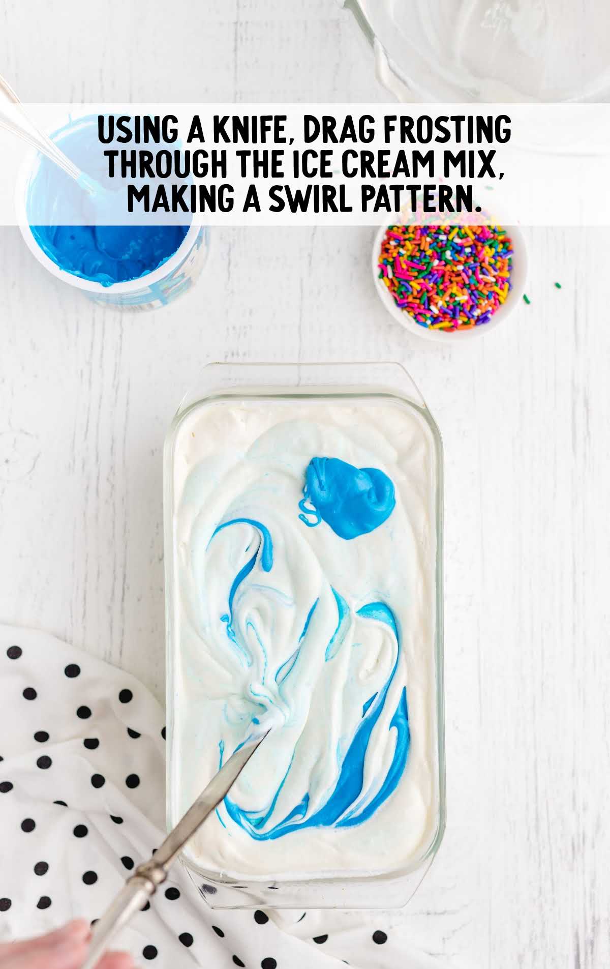 spreading frosting on the cake using knife in a baking dish