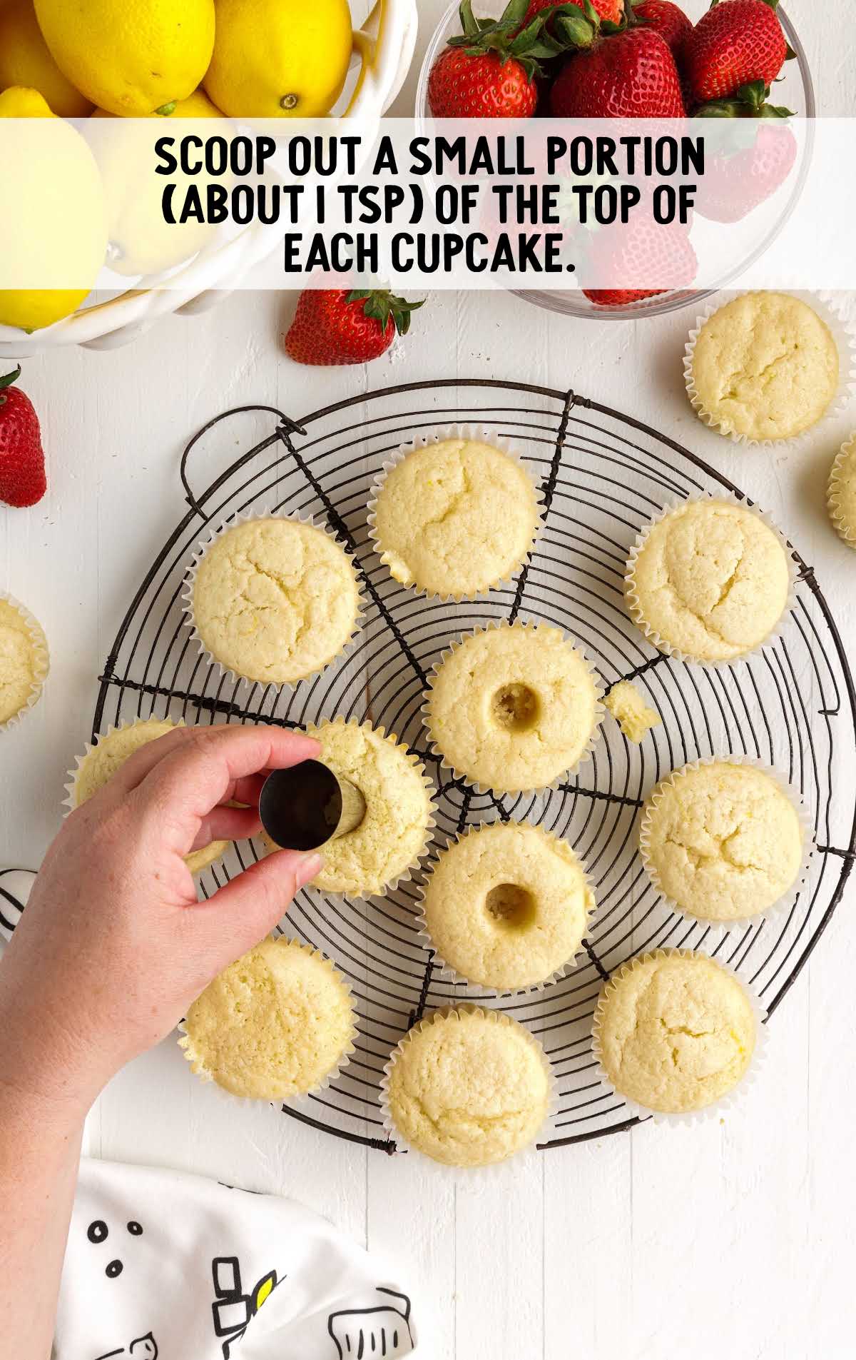 scooping out portions of each cupcake on a stand
