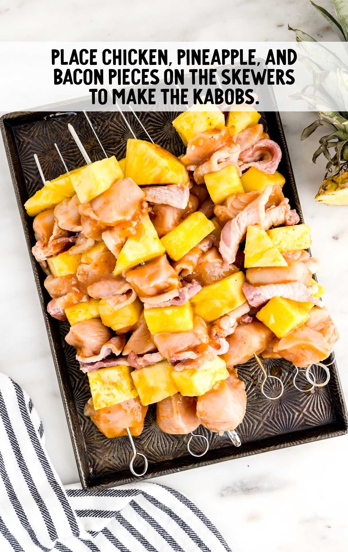 Chicken, pineapple and bacon pieces placed on the skewers