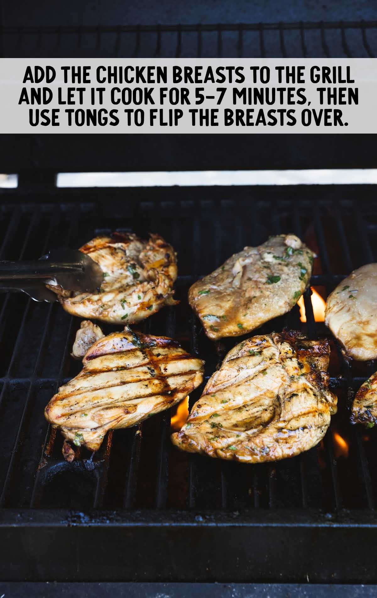chicken breast placed in the grill use tongs to flip over