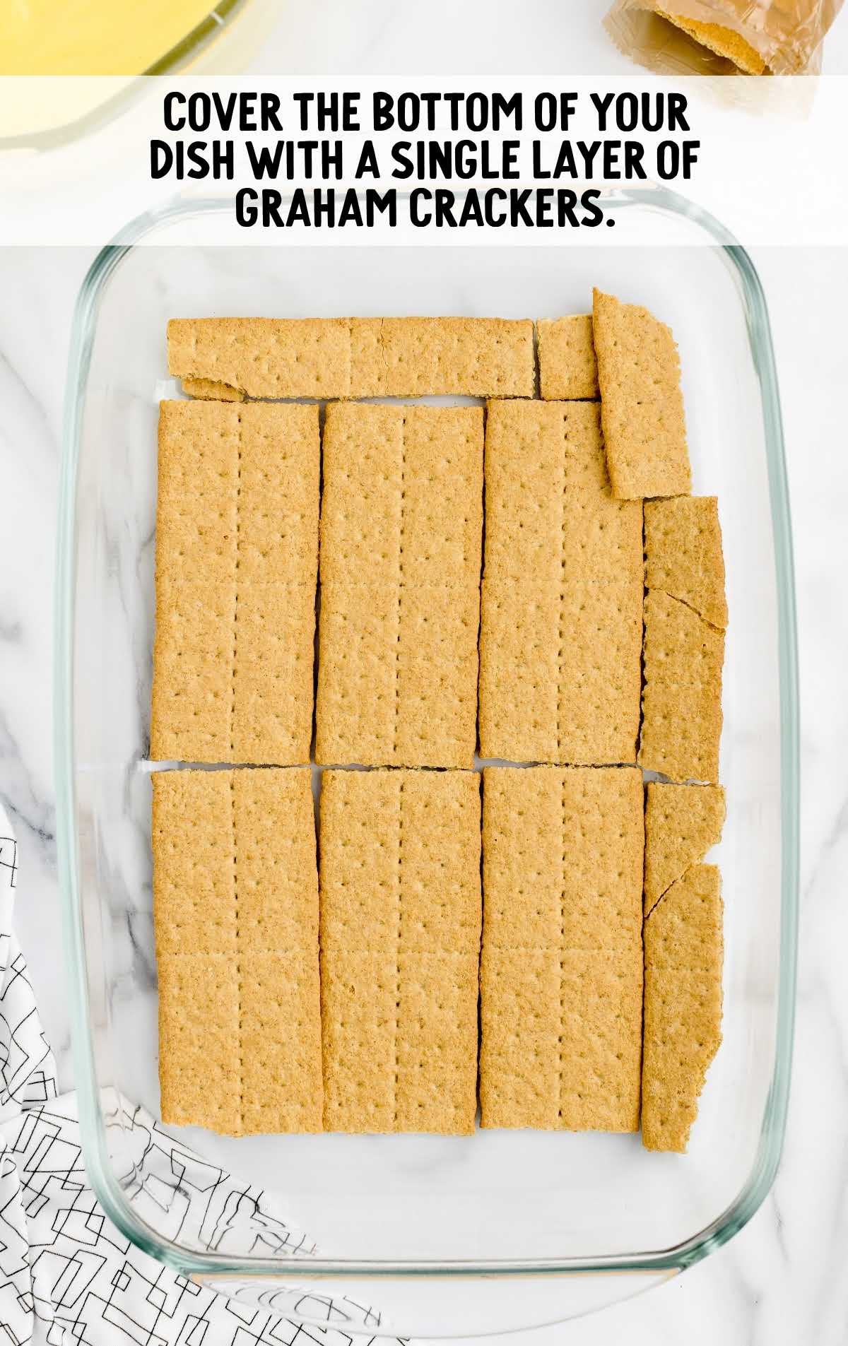 bottom layer covered with graham cracker in a baking dish