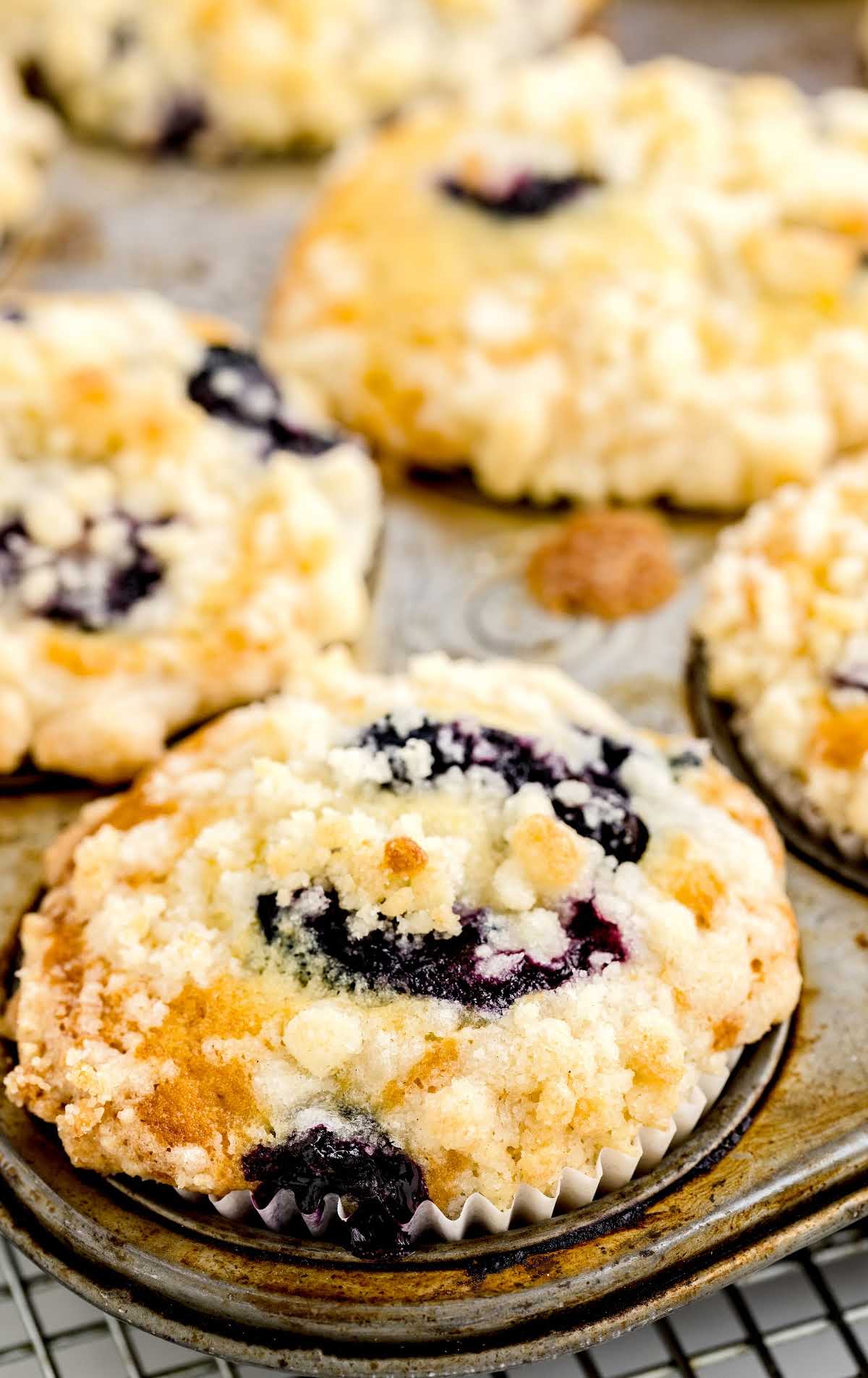 a close up shot of Blueberry Cobbler Muffins in a cupcake baking tray