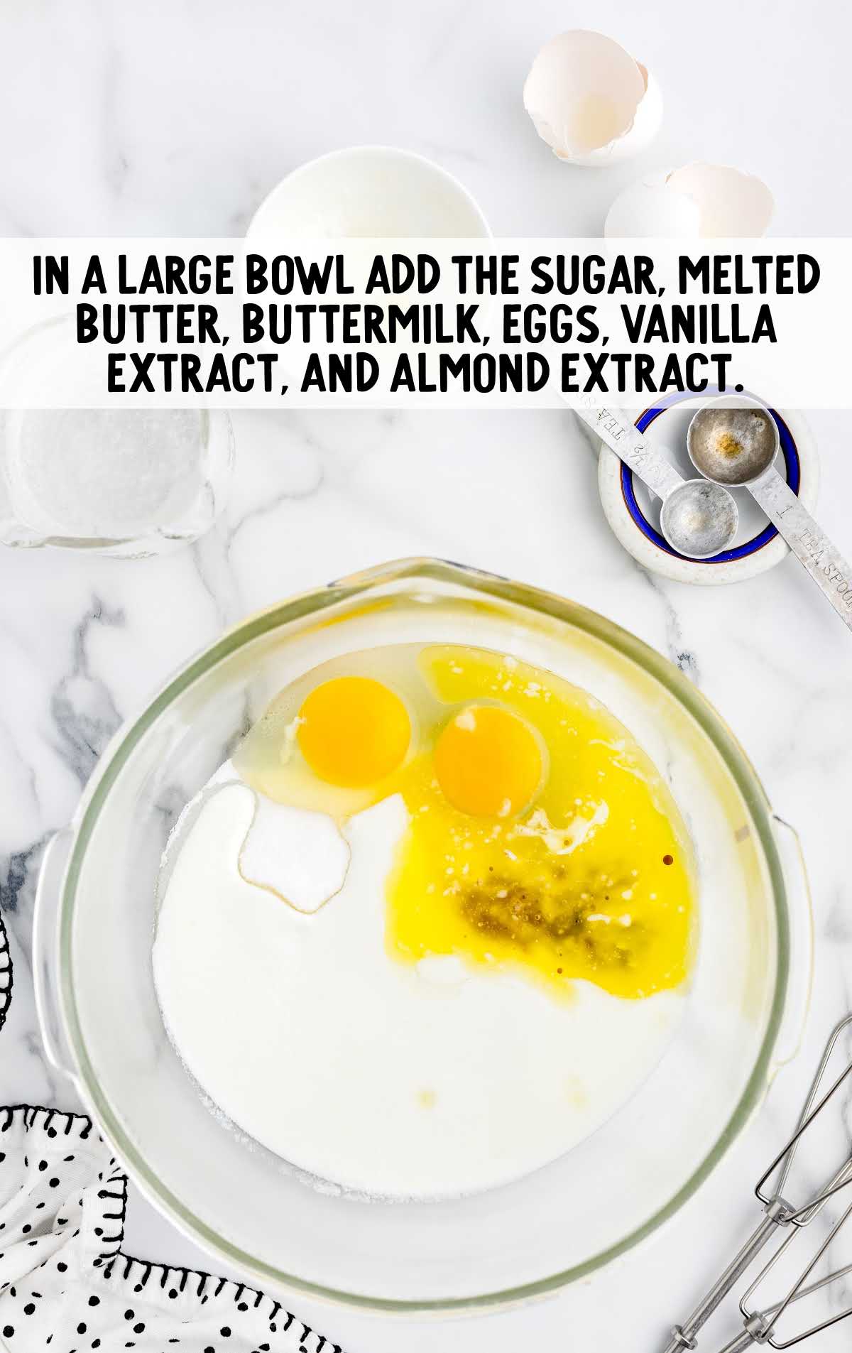 sugar, melted butter, buttermilk, eggs, vanilla extract, and almond extract mixed in a bowl