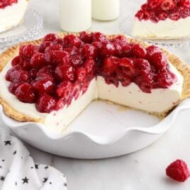 a close up shot of Raspberry Cream Cheese Pie in a pie dish with a slice taken out