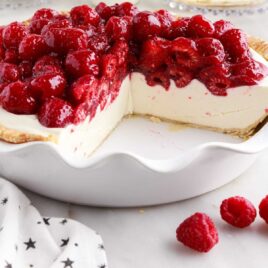 a close up shot of Raspberry Cream Cheese Pie in a pie dish with a slice taken out