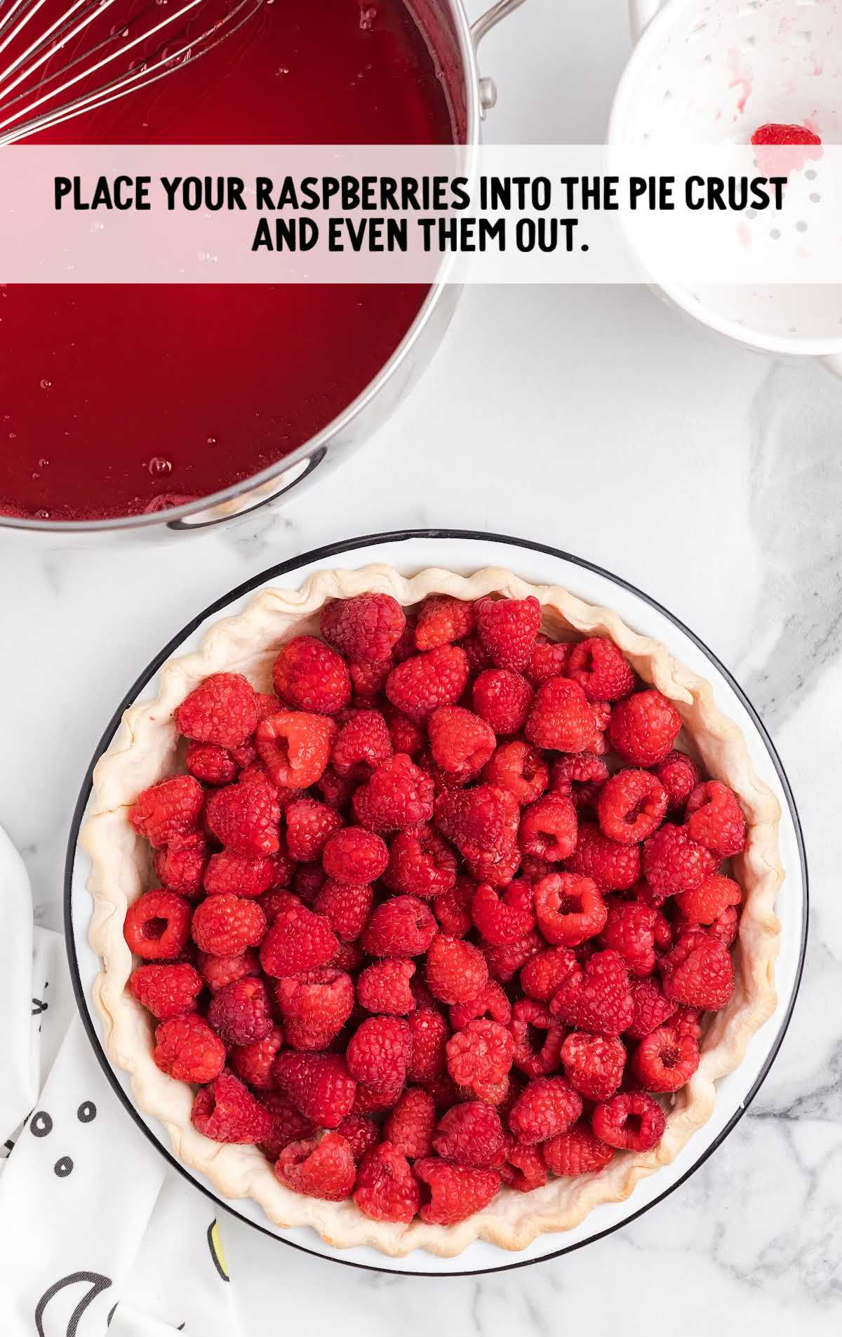raspberries placed into the pie crust on a plate