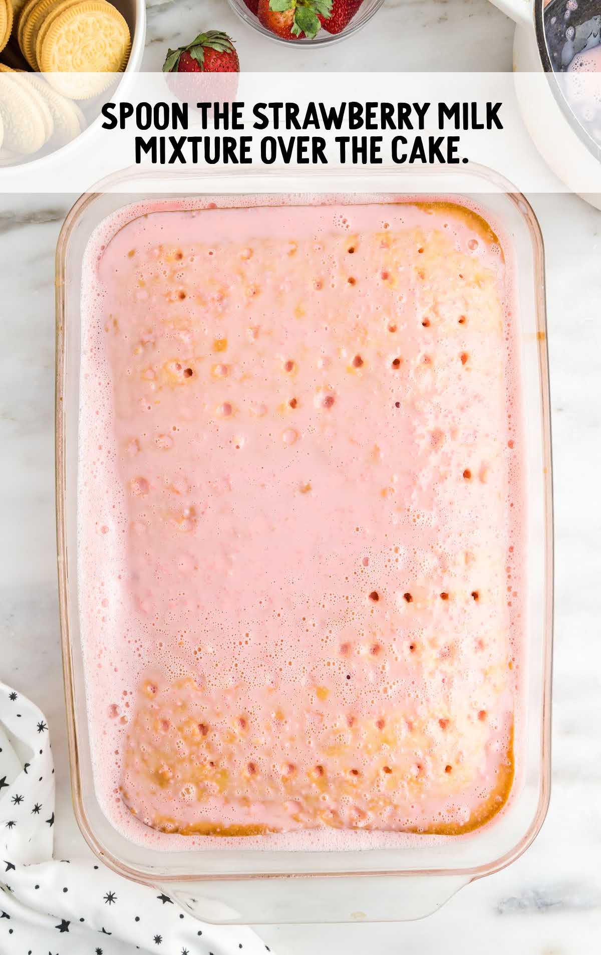 strawberry milk mixture spooned over the cake in a baking dish