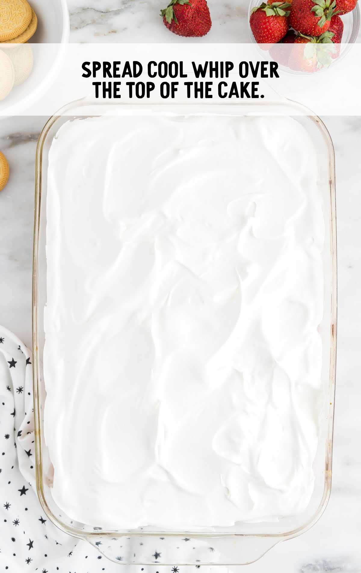 cool whip spread over the cake in a baking dish
