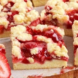 close up shot of slices of Strawberry Pie Bars on a wooden board