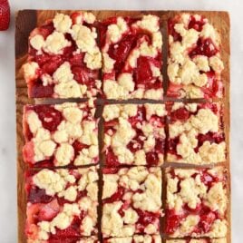 overhead shot of slices of Strawberry Pie Bars on a wooden cutting board
