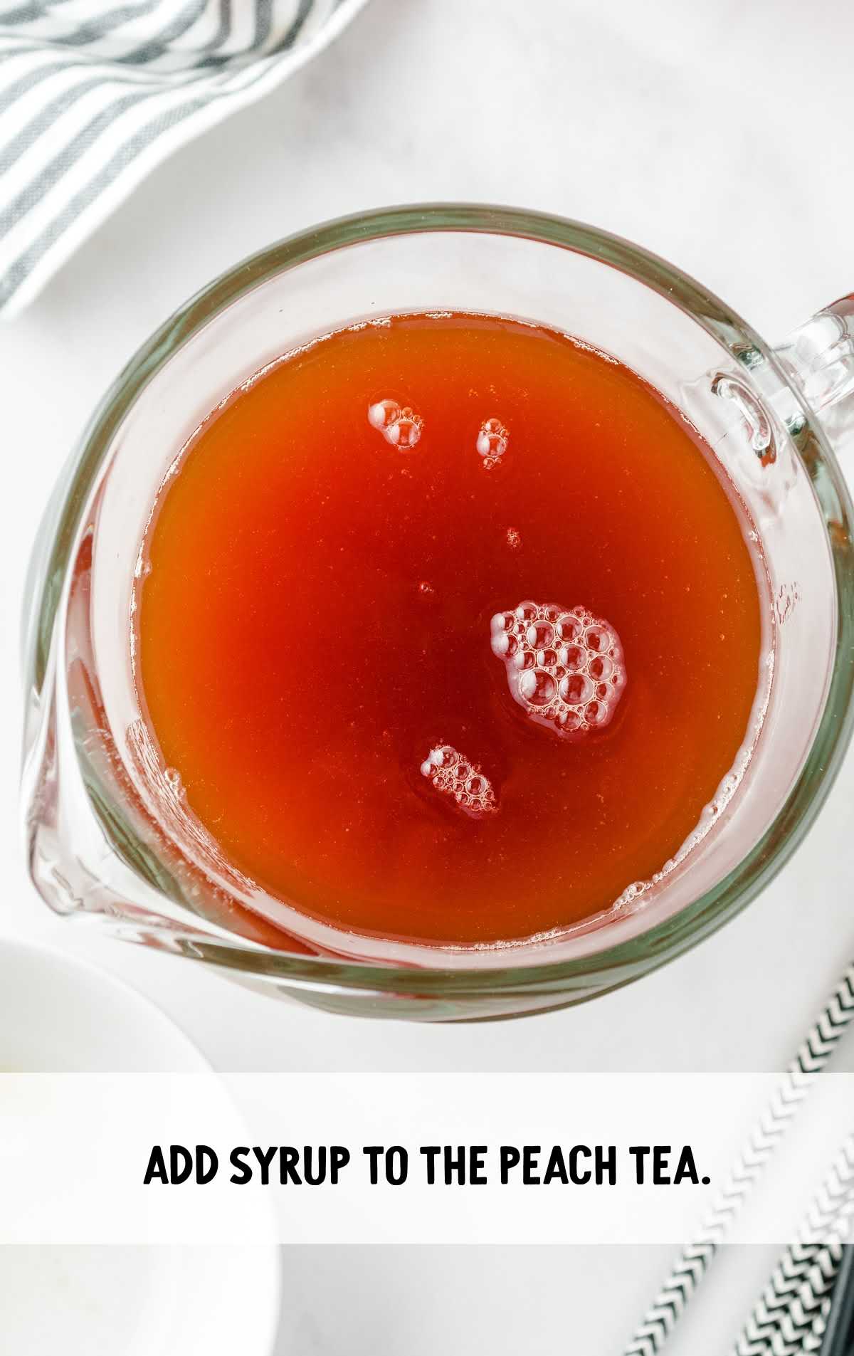 syrup added to the peach tea in a pitcher