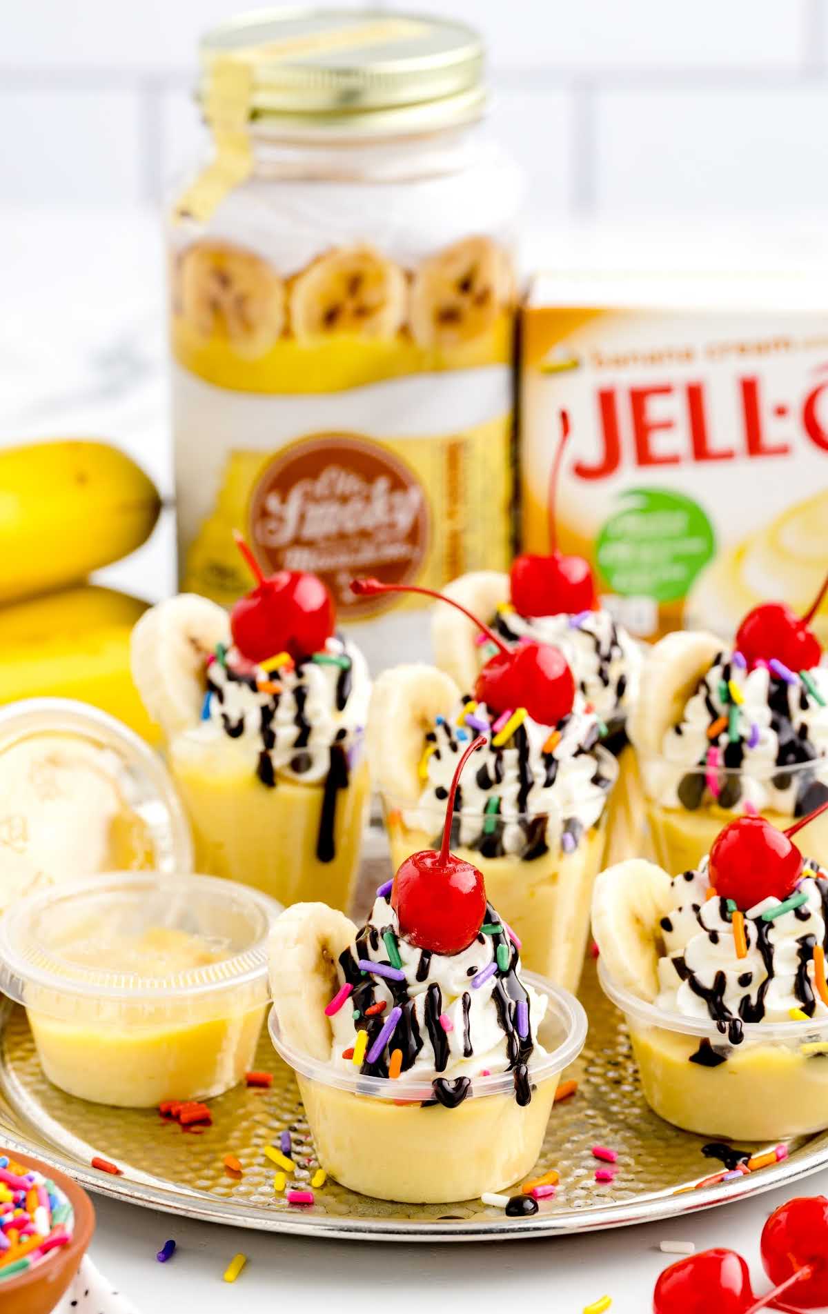 shot of Banana Split Jello Shots in a cup and on a platter