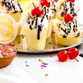 close up shot of Banana Split Jello Shots in a cup and on a platter