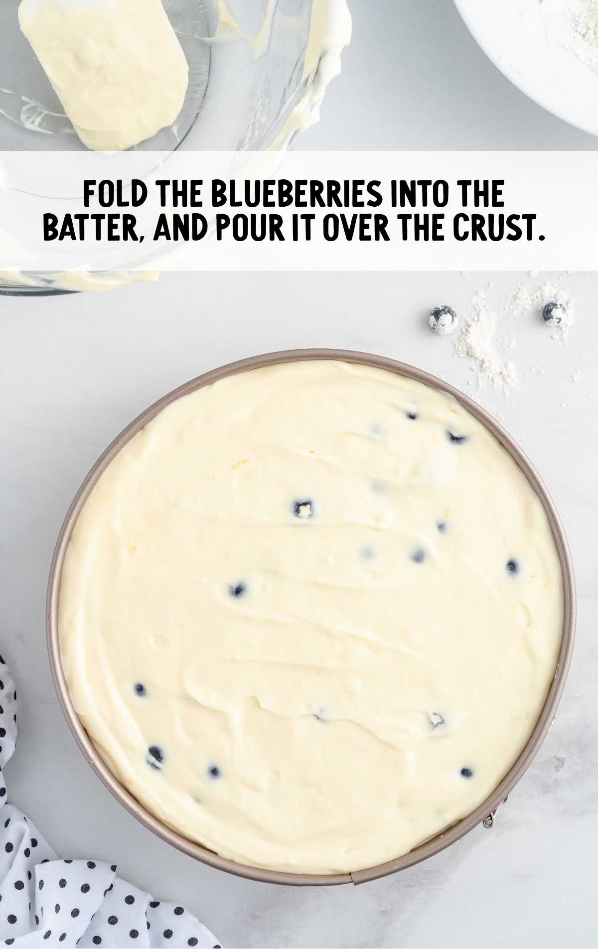 blueberries folded into the batter in a pan