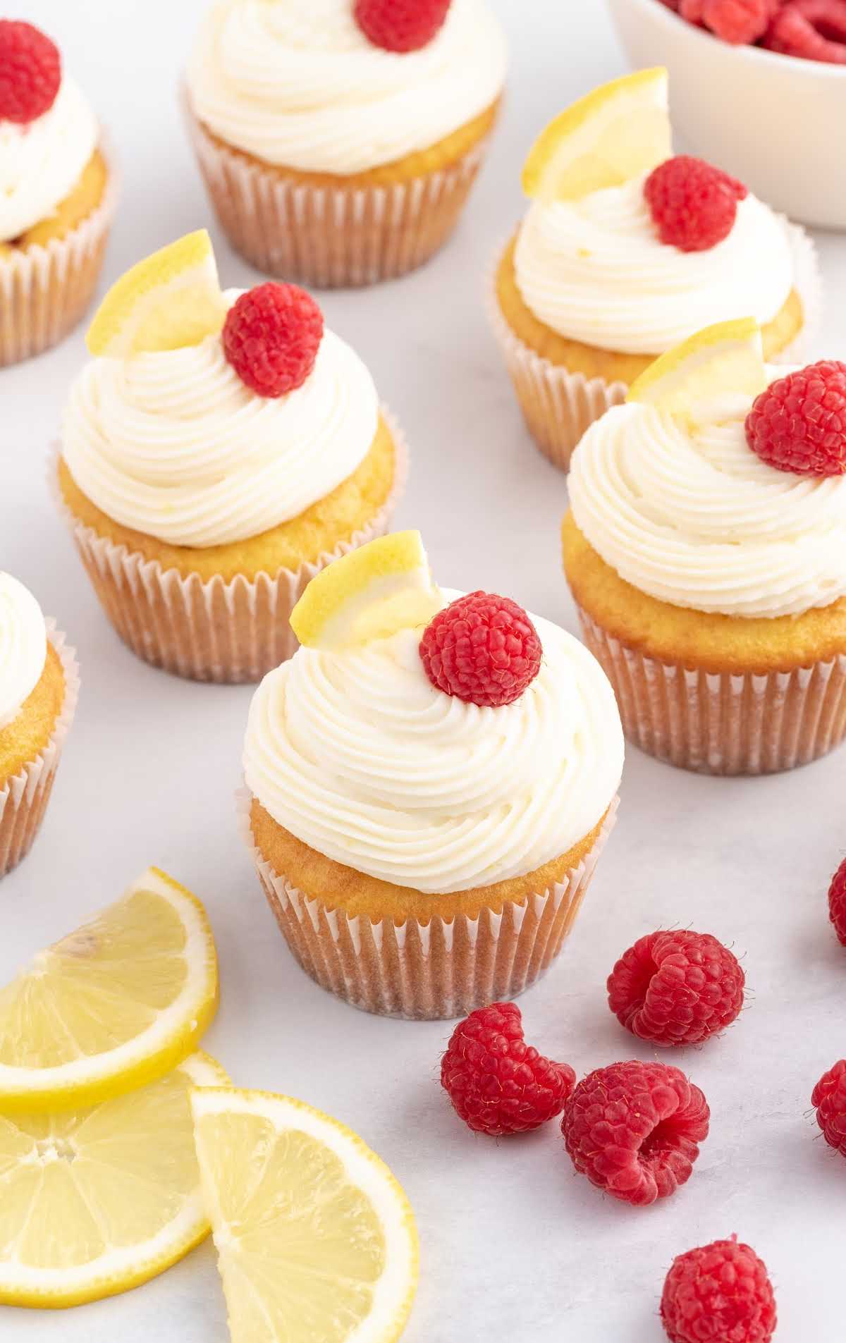 close up shot of Lemon Raspberry Cupcakes topped with a raspberry and a slice of lemon