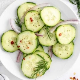 close up overhead shot of Pickled Cucumber Salad on a plate with sliced onions