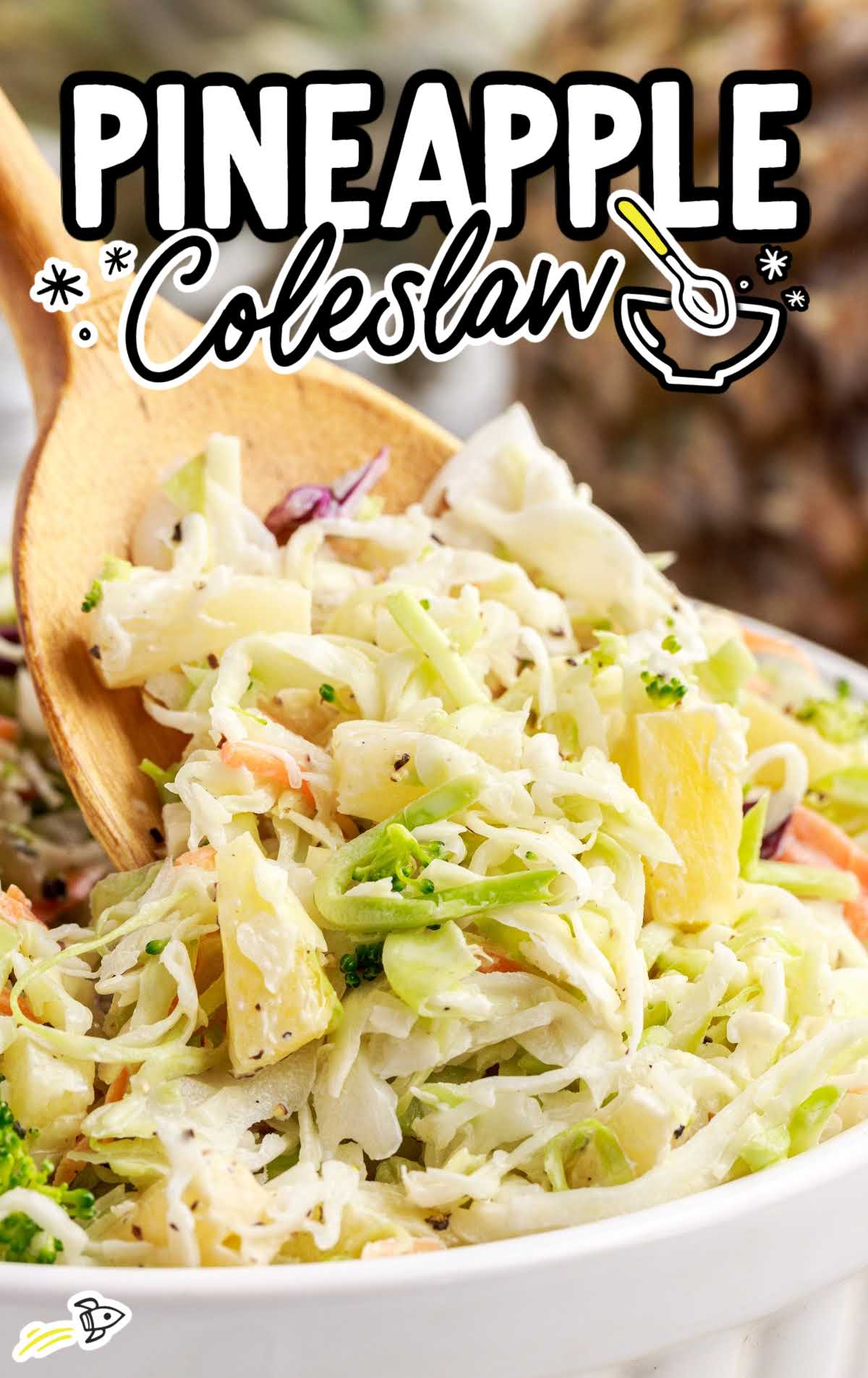 close up shot of Pineapple Coleslaw in a bowl with a spoon grabbing a piece