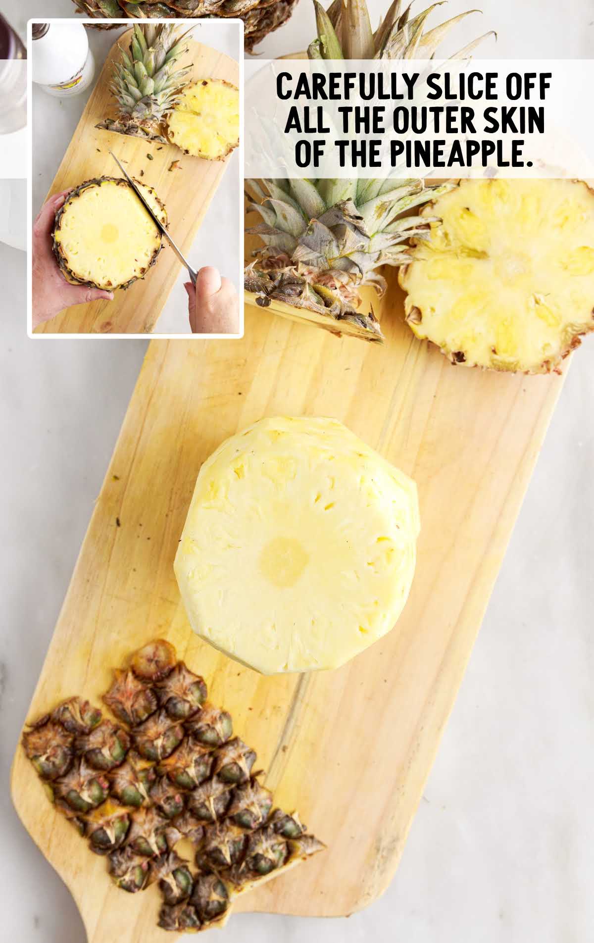 slicing off the outer skin of the pineapple on a cutting board